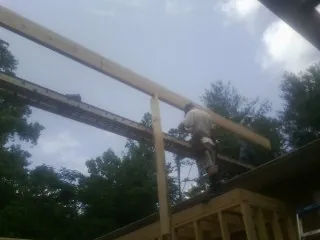 Carpenter setting a ridge beam over a new addition frame — Ice Dam Removal by Roofing Brothers in Leonardtown
