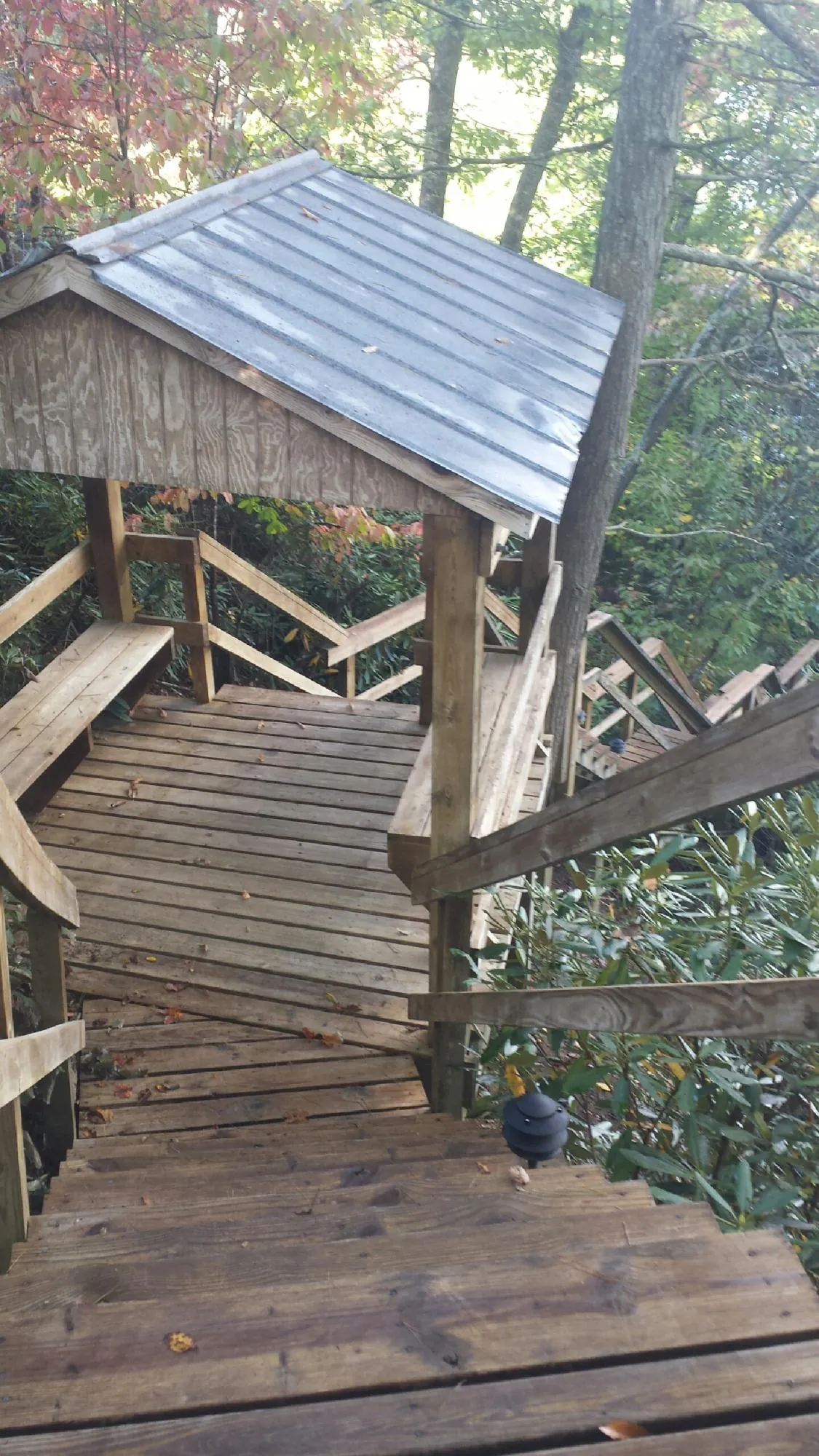 Metal roofed shelter over wooden steps on a wooded walkway — Skylight Repair & Installation work by our crew in Leonardtown