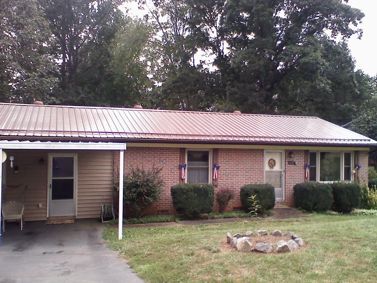 Bronze metal roof and carport on a brick ranch home — Roof Repair work by our crew in Leonardtown